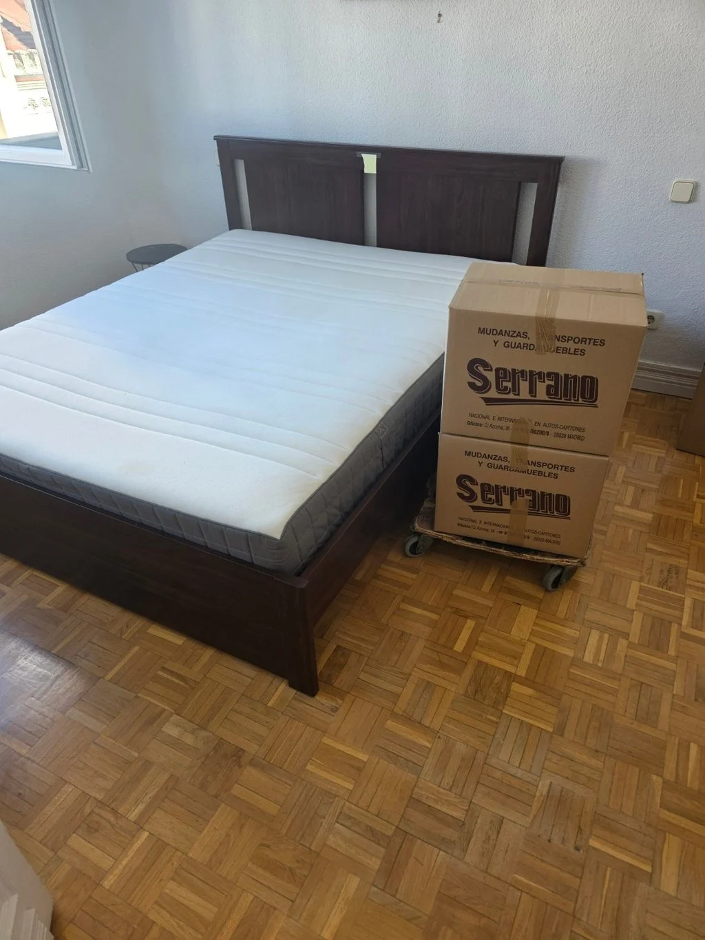 Cama y cajas de Mudanzas Serrano preparadas en una vivienda